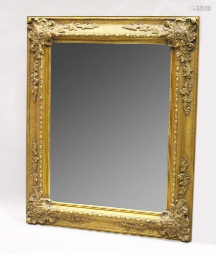 A LARGE GILT BEVELLED MIRROR with scrolling decoration,