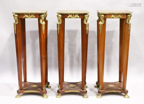 A SET OF THREE SQUARE TOP TORCHERES with mask mounts,