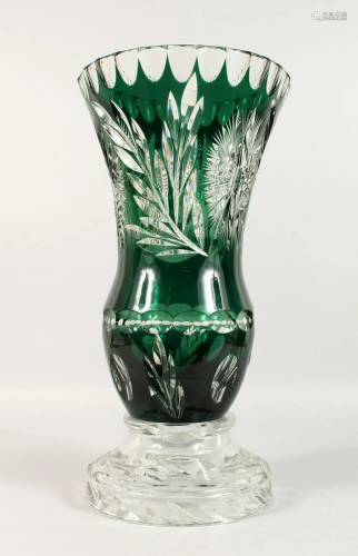 A LARGE BOHEMIAN GREEN CUT GLASS VASE on a plain