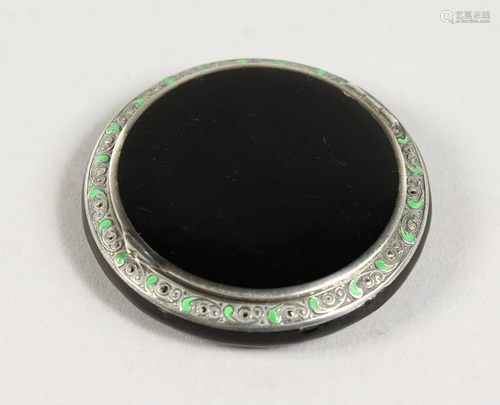 A SMALL SILVER AND BLACK ENAMEL CIRCULAR COMPACT