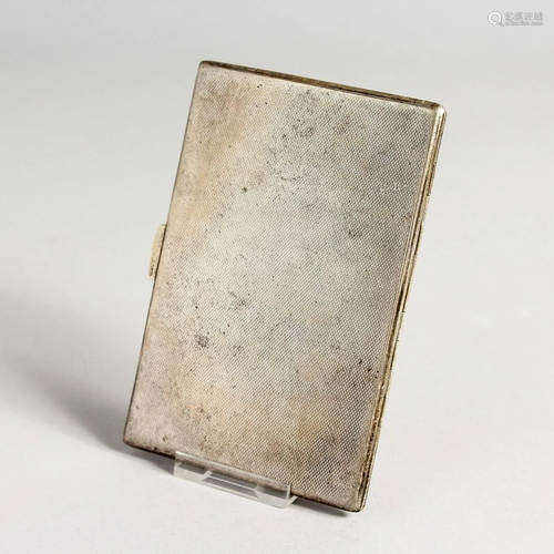 AN ENGINED TURNED SILVER CIGARETTE CASE complete with