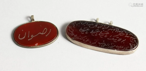 TWO ISLAMIC SILVER PENDANTS with calligraphy.
