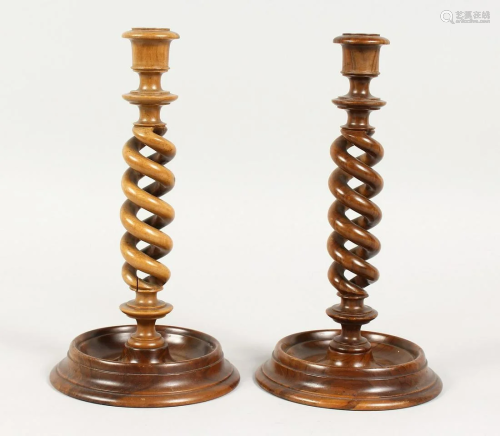 A PAIR OF TURNED SPIRAL OLIVE WOOD CANDLESTICKS 10 ins
