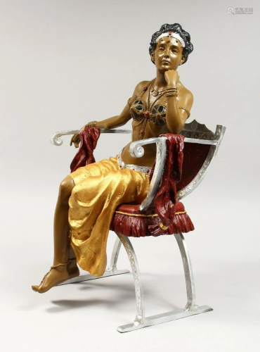 A PAINTED AND GILDED BRONZE GIRL sitiiing on a chair