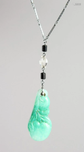 A CARVED JADE PENDANT on a chain.