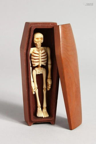 A WOODEN COFFIN AND BONE SKELETON 4.5 ins high.