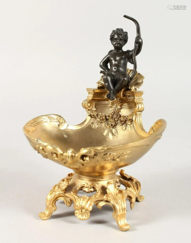 A GILT BRONZE CUPID SALT on a shell and acanthus base.