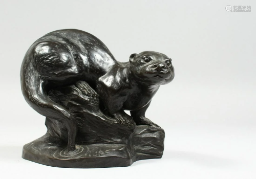 A BRONZED FIGURE OF A OTTER on a rocky base,signed T