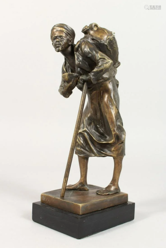 A BRONZE OF AN ARAB MAN with a book and a stick.