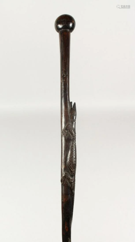 A NATIVE WOODEN WALKING STICK carved with an rep…