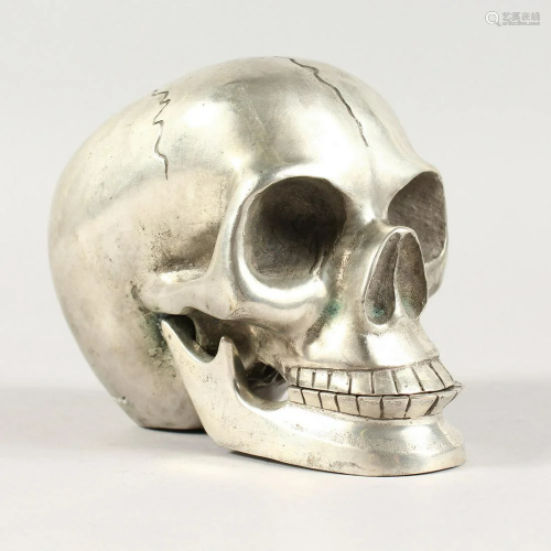 A WHITE METAL ARTICULATED SKULL 4.5 ins