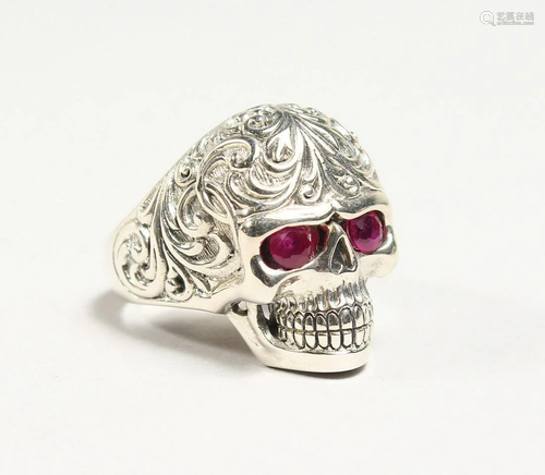 A SILVER RUBY EYE SKULL RING