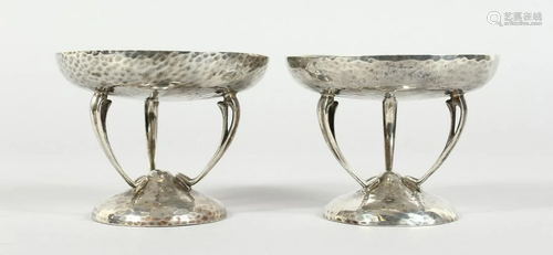 A PAIR OF HAMMERED SILVER SWEETMEAT DISHES on three