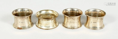 FOUR VARIOUS SILVER SERVIETTE RINGS.