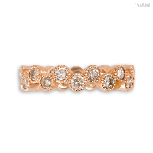 A diamond and eighteen karat rose gold band ring
