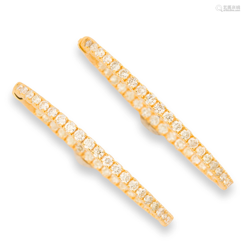 A pair of diamond and fourteen karat gold hoop earrings