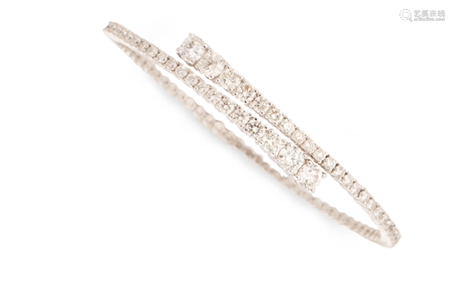 A diamond and fourteen karat white gold bangle bracelet