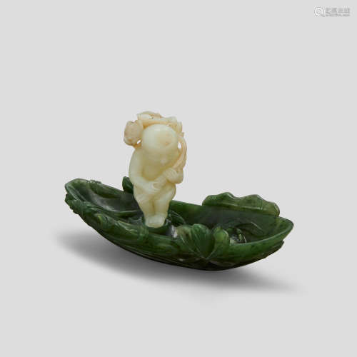 A spinach and white jade carving of a boy and lotus