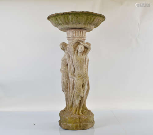 A reconstituted stone birdbath, modelled as the three graces...