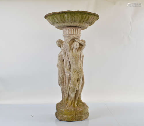 A reconstituted stone birdbath, modelled as the three graces...