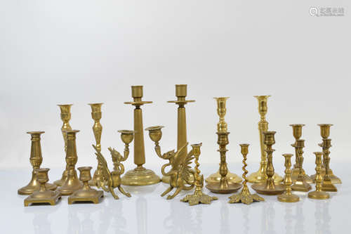 A quantity of brass candlesticks, including a pair of griffi...