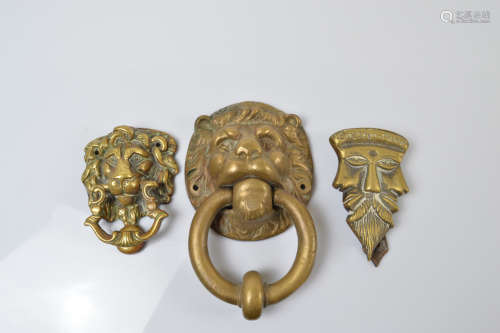 Three brass door knockers, two in the form lion heads with r...