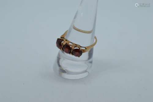 A 9ct gold three stone garnet dress ring, the three circular...