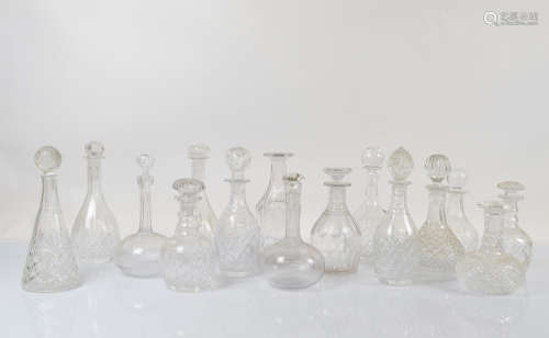 A collection of cut glass decanters with associated stoppers...