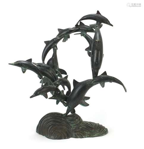 Large patinated bronzed study of a pod of dolphins above wav...