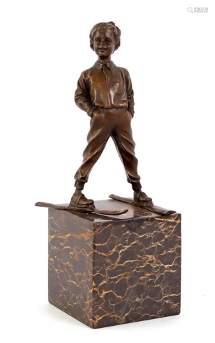 Bronze sculpture of a boy on skis, on marble base