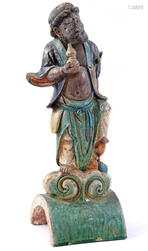 Antique earthenware roof statue of a man with a jug,