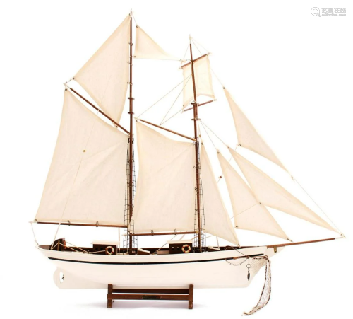 Wooden scale model sailing boat on standard