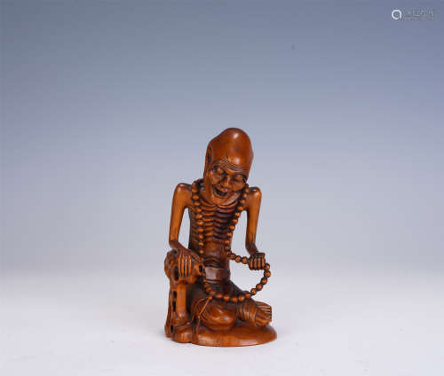 A CHINESE BOXWOOD LUOHAN SEATED STATUE