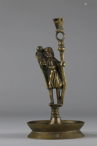 Bronze candlestick surmounted by a character probably