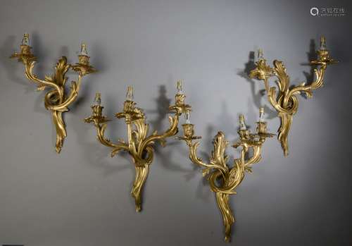 Suite de sept appliques en bronze doré à deux bras de lumièr...