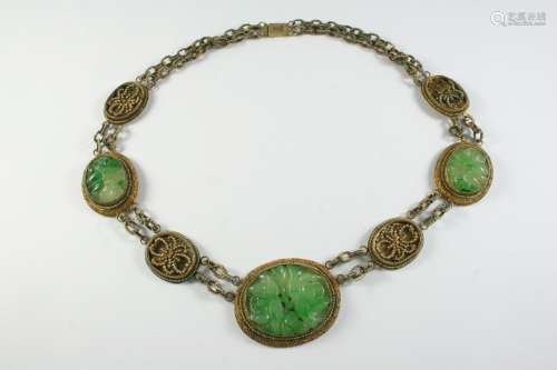 A CHINESE JADE NECKLACE formed with three oval-shaped pierce...