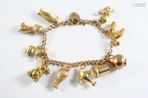 A GOLD CURB LINK CHARM BRACELET with padlock clasp and mount...