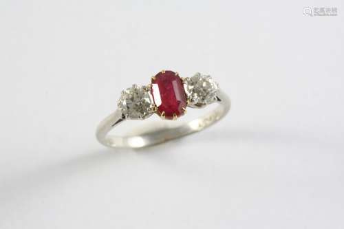 A RUBY AND DIAMOND THREE STONE RING the oval-shaped ruby is ...