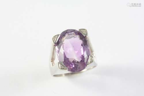 AN AMETHYST AND DIAMOND RING the oval-shaped amethyst is set...