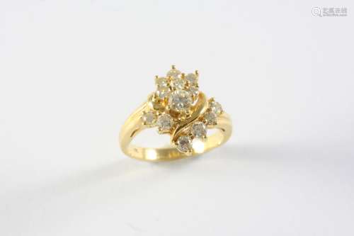 A DIAMOND CLUSTER RING mounted with graduated circular-cut d...