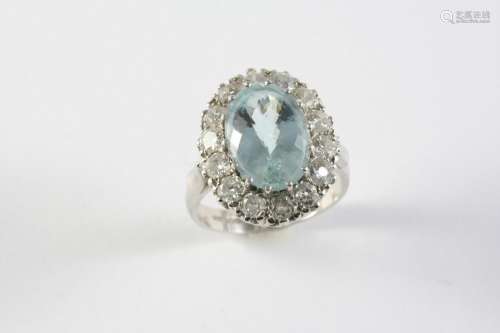 AN AQUAMARINE AND DIAMOND CLUSTER RING the oval-shaped aquam...