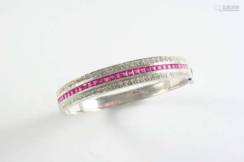 A RUBY AND DIAMOND HALF HINGED BANGLE set to one side with a...