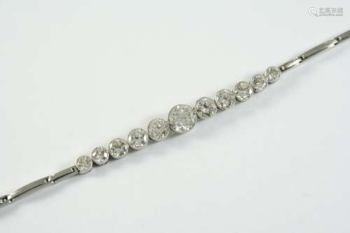 A DIAMOND BRACELET formed with eleven circular collet set di...