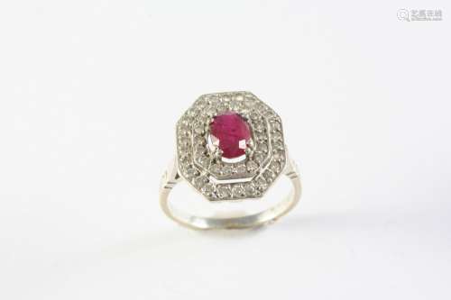 A RUBY AND DIAMOND CLUSTER RING the oval-shaped ruby is set ...