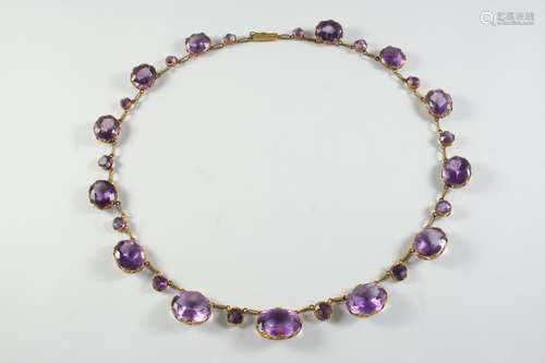 AN AMETHYST AND GOLD NECKLACE formed with graduated oval-sha...