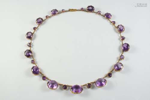 AN AMETHYST AND GOLD NECKLACE formed with graduated oval-sha...