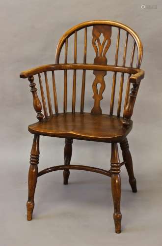 A LOW BACKED BEECH AND ELM WINDSOR ARM CHAIR, the hooped bac...
