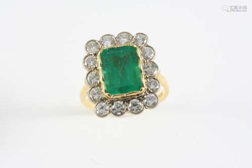 AN EMERALD AND DIAMOND CLUSTER RING the rectangular-shaped e...