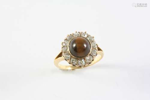 A TIGER'S EYE AND DIAMOND CLUSTER RING the circular cabochon...