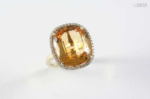 A TOPAZ AND DIAMOND CLUSTER RING the oval-shaped topaz is se...